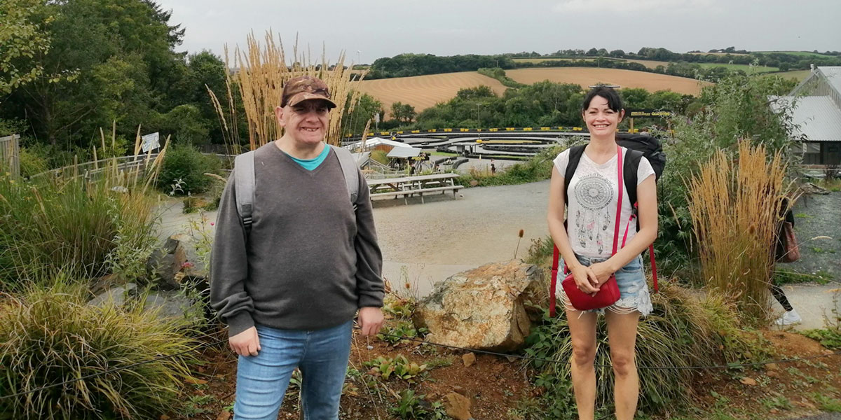 Photo of two people with a gokart track site in the background.
